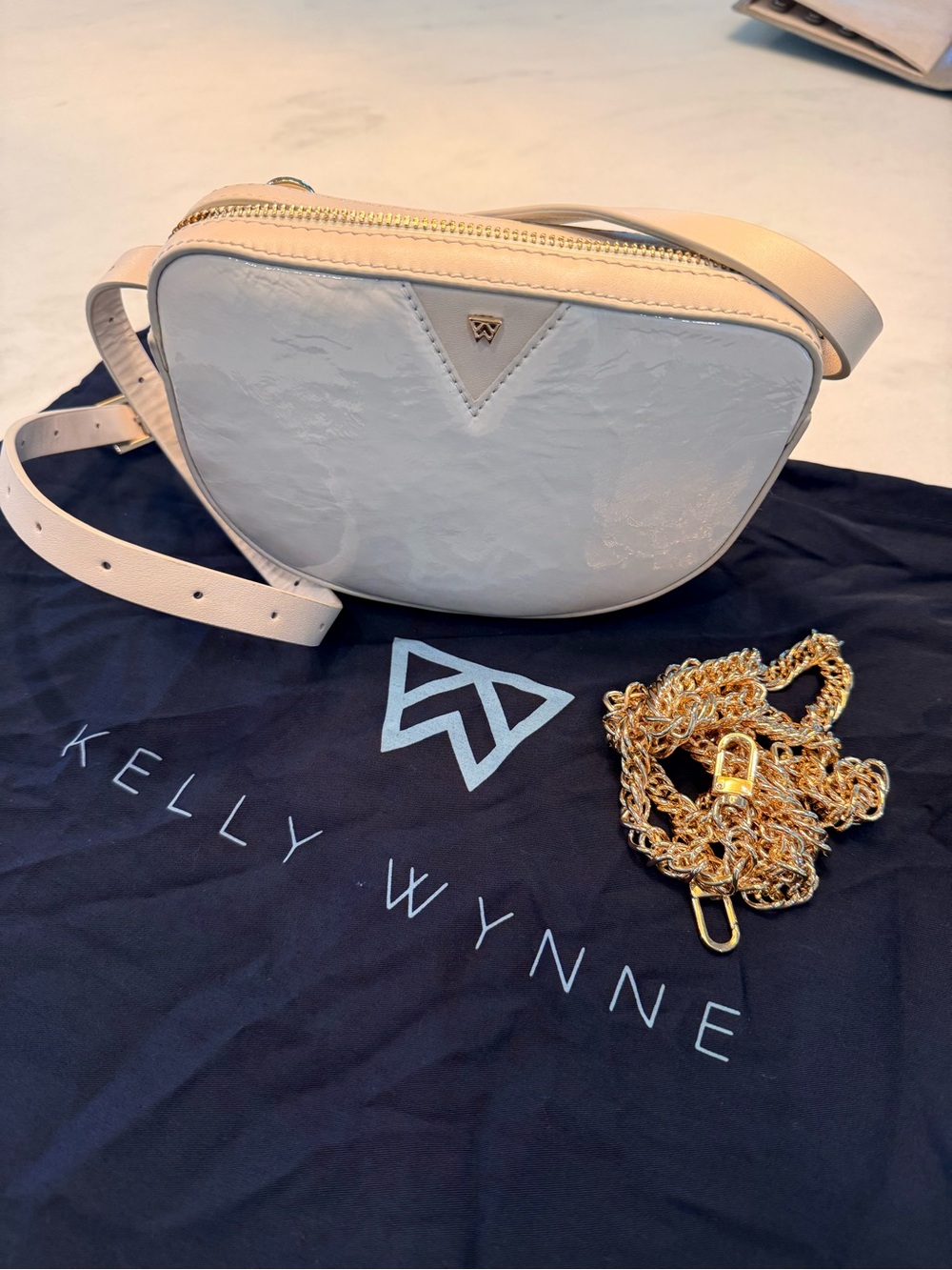 Kelly Wynne white patent leather crossbody bag with gold hardware